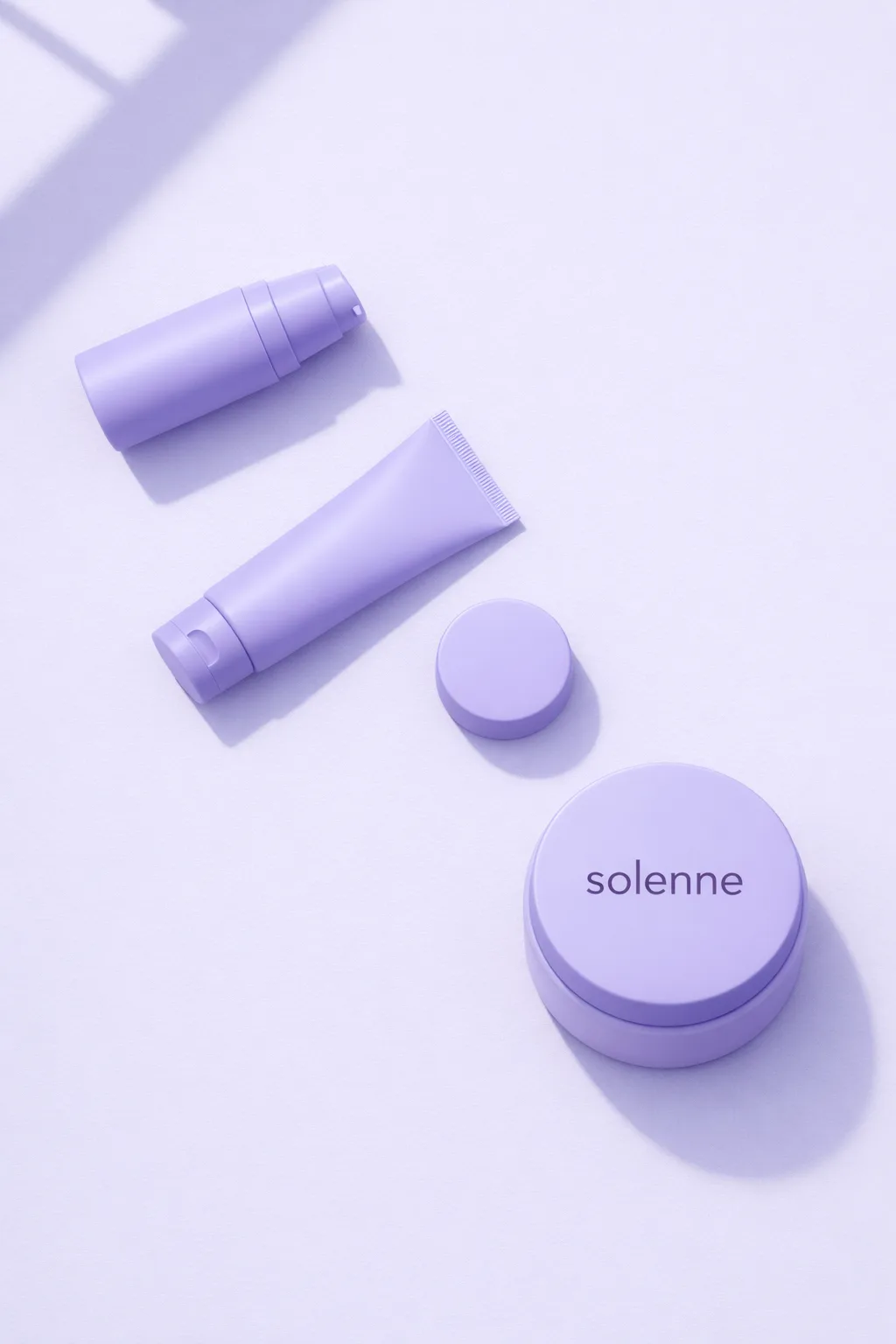 Lilac pump bottle, tube and jar lid laid out beside a finished branded cream jar
